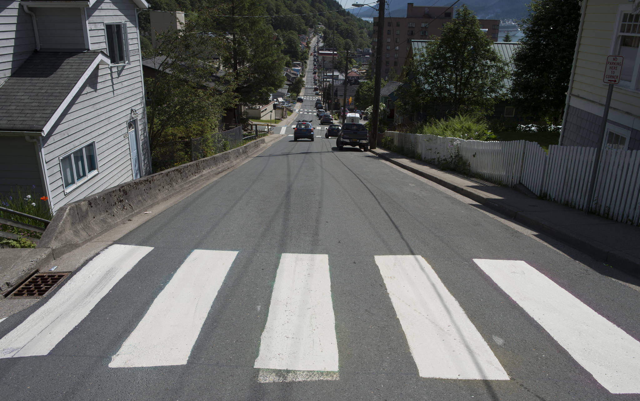 A crosswalk on Gold Street at 7th Street sports freshly painted white strips on Wednesday, June 20, 2018. The crosswalk had been painted with a rainbox of colors which the city has said is vandalism. (Michael Penn | Juneau Empire)