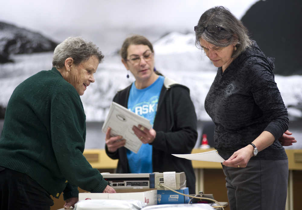 Juneau Municipal Clerk Laurie Sica, right, looks over an "over counted" ballot during questioned and absentee vote counting in the Assembly chambers on Friday. An "over counted" ballot shows more than one candidate was voted for in a single race.