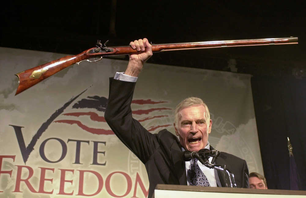 In this Oct. 21, 2002 photo, National Rifle Association President Charlton Heston holds up a rifle as he addresses gun owners during a "get-out-the-vote" rally in Manchester, New Hampshire.