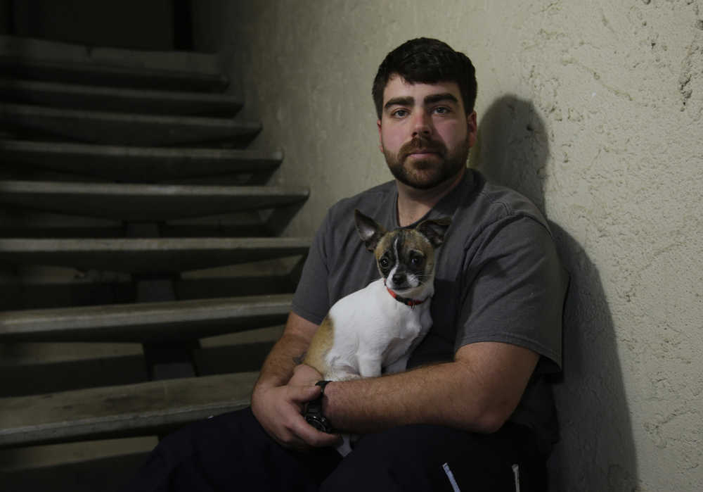 In this photo taken Thursday, Dec. 17, 2015, Josh Redmyer, a former Marine who served three tours in Iraq, poses with Milo, who he calls his "therapy dog," in Oroville, Calif. Redmyer, who was diagnosed with Post-Traumatic Stress Disorder in 2009,  received a less-than-honorable discharge in 2012. He is among the thousands of veterans who cannot receive veterans health benefits because of a less-than-honorable discharge. Redmyer turns to Milo, who is a birthday present from his roommate, when he becomes despondent. (AP Photo/Rich Pedroncelli)