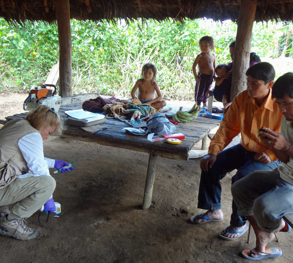 In this photo provided by Science Advances, microbiologist Maria Gloria Dominguez-Bello collects temperature information of the floor at one of a Checherta hut. Whether it's a jungle hut or a high-rise apartment, your home is covered in bacteria, and new research from the Amazon suggests city dwellers might want to open a window.