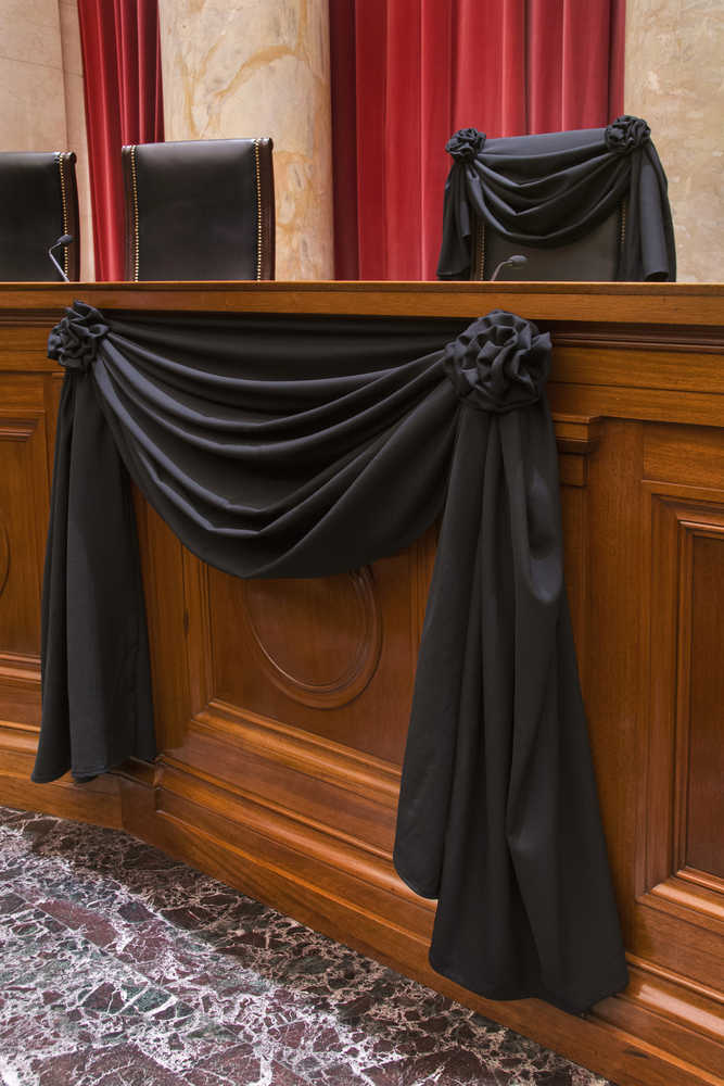 This photo provided by the Collection of the Supreme Court of the United States shows Supreme Court Associate Justice Antonin Scalia's Bench Chair and the Bench in front of his seat draped in black, Tuesday, Feb. 16, 2016, at the court in Washington, following his death on Feb. 13, 2016.  (Franz Jantzen/Collection of the Supreme Court of the United States via AP)