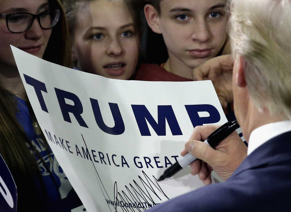 Republican presidential candidate Donald Trump autographs for supporters during a rally at Wexford County Civic Center, Friday, March 4, 2016, in Cadillac, Mich. (AP Photo/Nam Y. Huh)