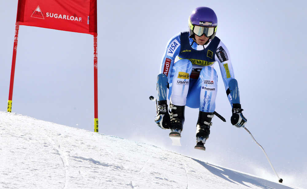 In this March 25, 2015 photo, Drew Duffy, of Warren, Vt., catches some air on his run during the men's super-G skiing race at the U.S. Alpine Ski Championships at Sugarloaf Mountain Resort in Carrabassett Valley, Maine.  Duffy wears the initials "BA" and "RB" on his helmet in memory of highly touted skiing prospects and good friends Bryse Astle and Ronnie Berlack, killed in an avalanche in Soelden, Austria just over a year ago.