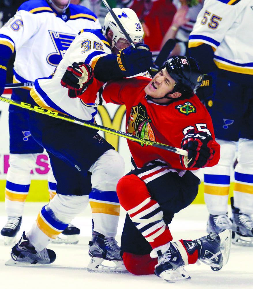 Chicago Blackhawks center Andrew Shaw (65) gets knocked down by St. Louis Blues right wing Troy Brouwer (36) as Shaw tries to skate off to celebrate with his teammates after Duncan Keith (2) scored a goal during the second period in Game 4 of an NHL hockey first-round Stanley Cup playoff series Tuesday, April 19, 2016, in Chicago. (AP Photo/Nam Y. Huh)