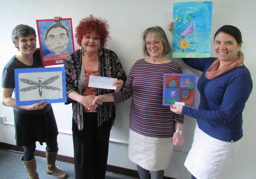 Cindy Hudson of the Women of the Moose presents the award to Nancy DeCherney, executive director of JAHC. Nancy Lehnhart, Juneau School District Art Specialist is on the left. Jen LaRoe, Juneau Arts & Humanities Council Education Director, is on the right.