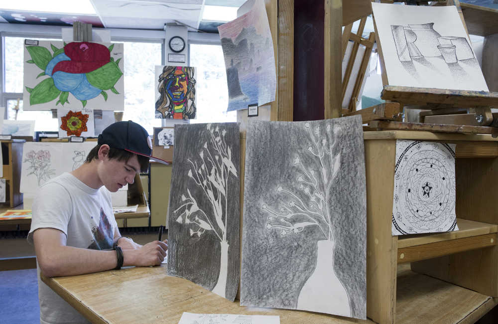 Senior Soren Thompson writes about artwork on display at the Semester Art Show the Juneau-Douglas High School Art Studios on Thursday.