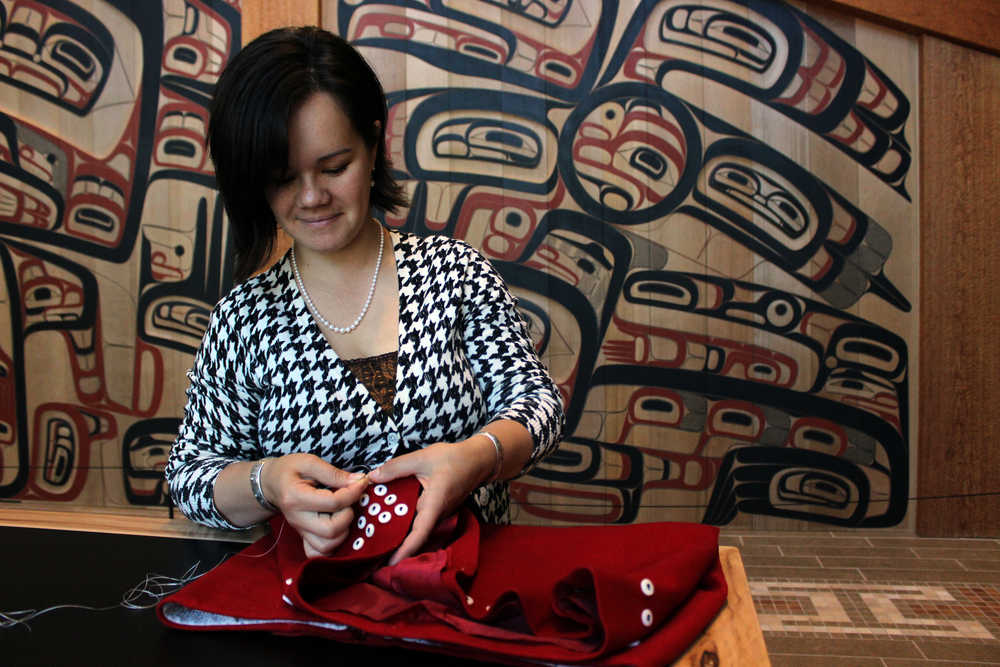 Tlingit weaver Lily Hope works at the Sealaska Heritage Institute on a button design for a red wool skirt she is submitting for this year's Celebration Native Fashion Show. Hope worked alongside her aunt Deanna Lampe to create culturally-sensitive fashion that can be worn by Native and non-Native people alike.