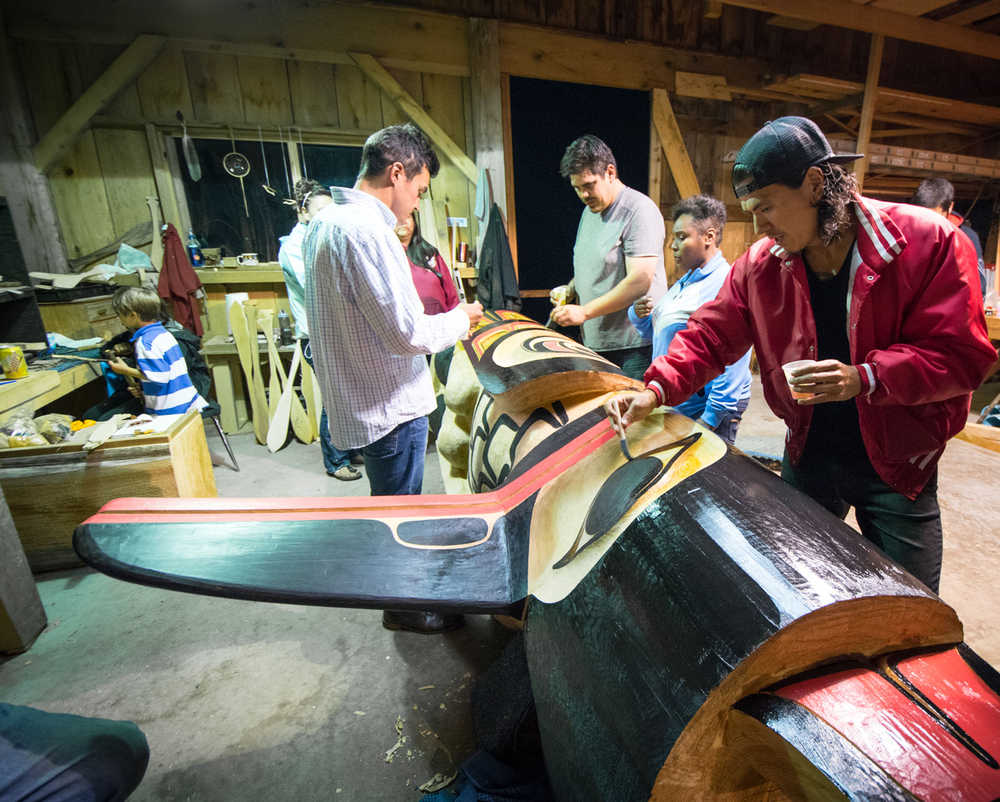 TJ Young, right, paints a totem pole he helped carve at Culture Camp last year in Hydaburg.