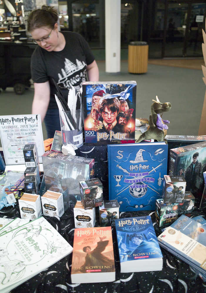 Elizabeth Ekins, an employee at Hearthside Books & Toys in the Nugget Mall, straightens a table with Harry Potter books and merchandise on July 20. The bookstore is hosting a party on Saturday, July 30, for the latest offering in the wizarding world saga.