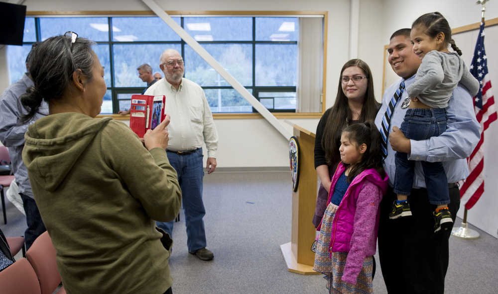 Officer Sean Ahshapanek has his picture taken with long-time partner Barbara Dude and their children, Michelle, 8, and Shaunde, 3, after being sworn into the Juneau Police Department on Friday.