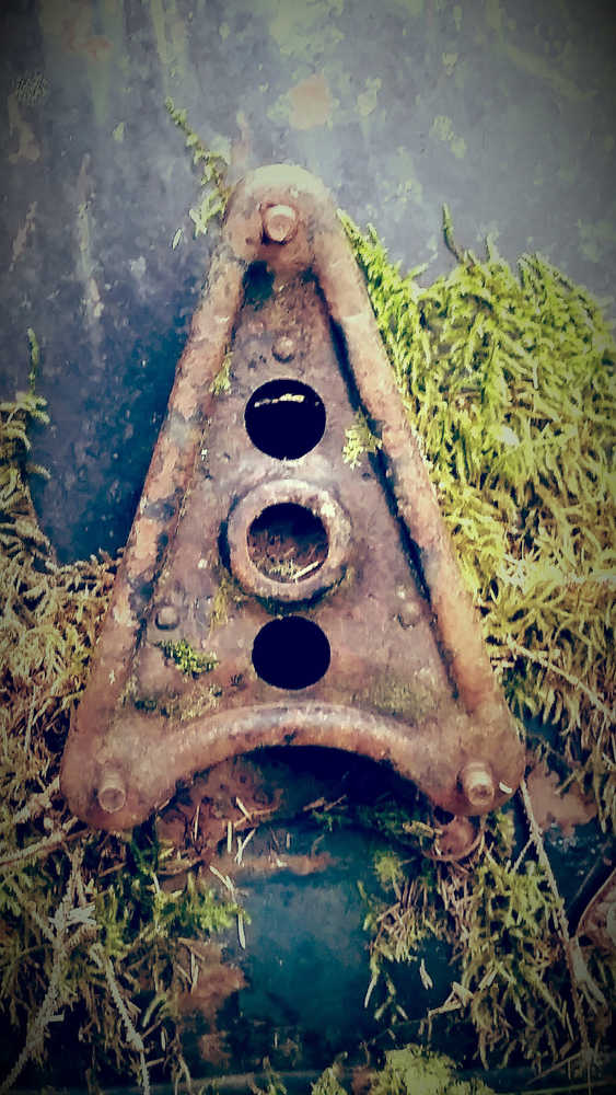 The tail end of a rusty vintage car.