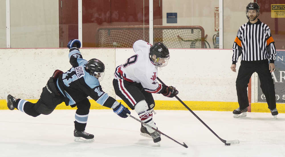 Juneau-Douglas' Niko Hebert, right, races Hutchison's Russell Savok to the goal at Treadwell Arena on Friday, Nov. 18, 2016.