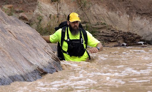 In this Sept. 16, 2015 file photo, a member of a search and rescue team wades in to Virgin River during a search in Zion National Park, near Springdale, Utah. Zion National Park officials are retracing what led up to the deaths of seven people in a flooded canyon on Sept. 15 before a panel assesses what can be done to keep a growing number of visitors safe when spectacular natural settings turn perilous.
