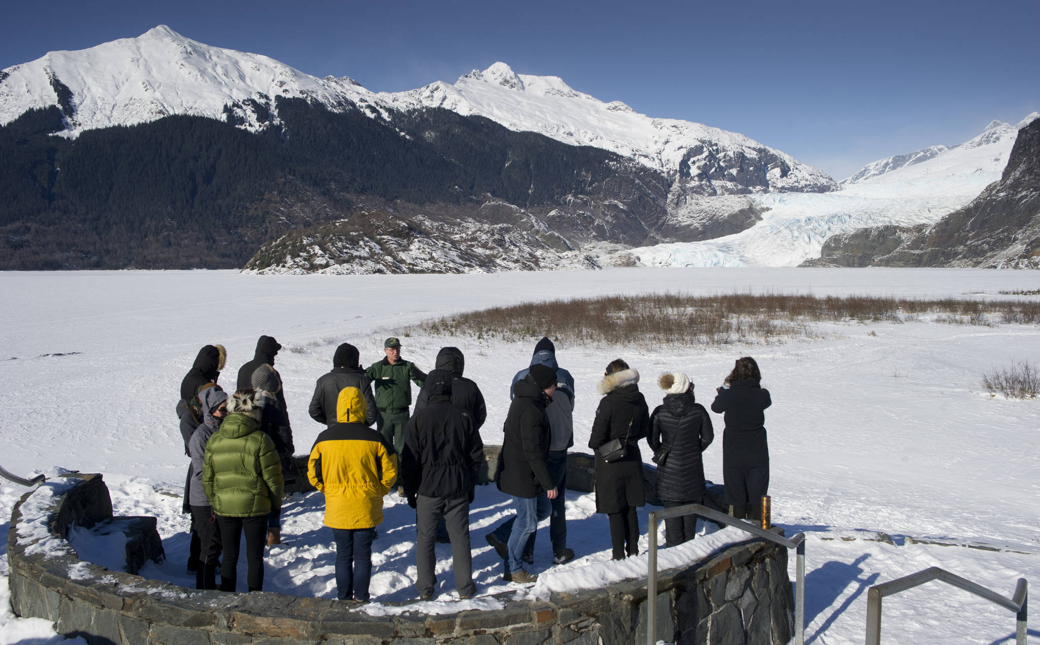 MICHAEL PENN | JUNEAU EMPIRE John Neary, director of the Mendenhall Glacier Visitor Center, gives a tour on Monday at Photo Point to representatives of Arctic nations in Juneau for Arctic Council Senior Arctic Official meetings this week. About 150 representatives will attend the meetings.