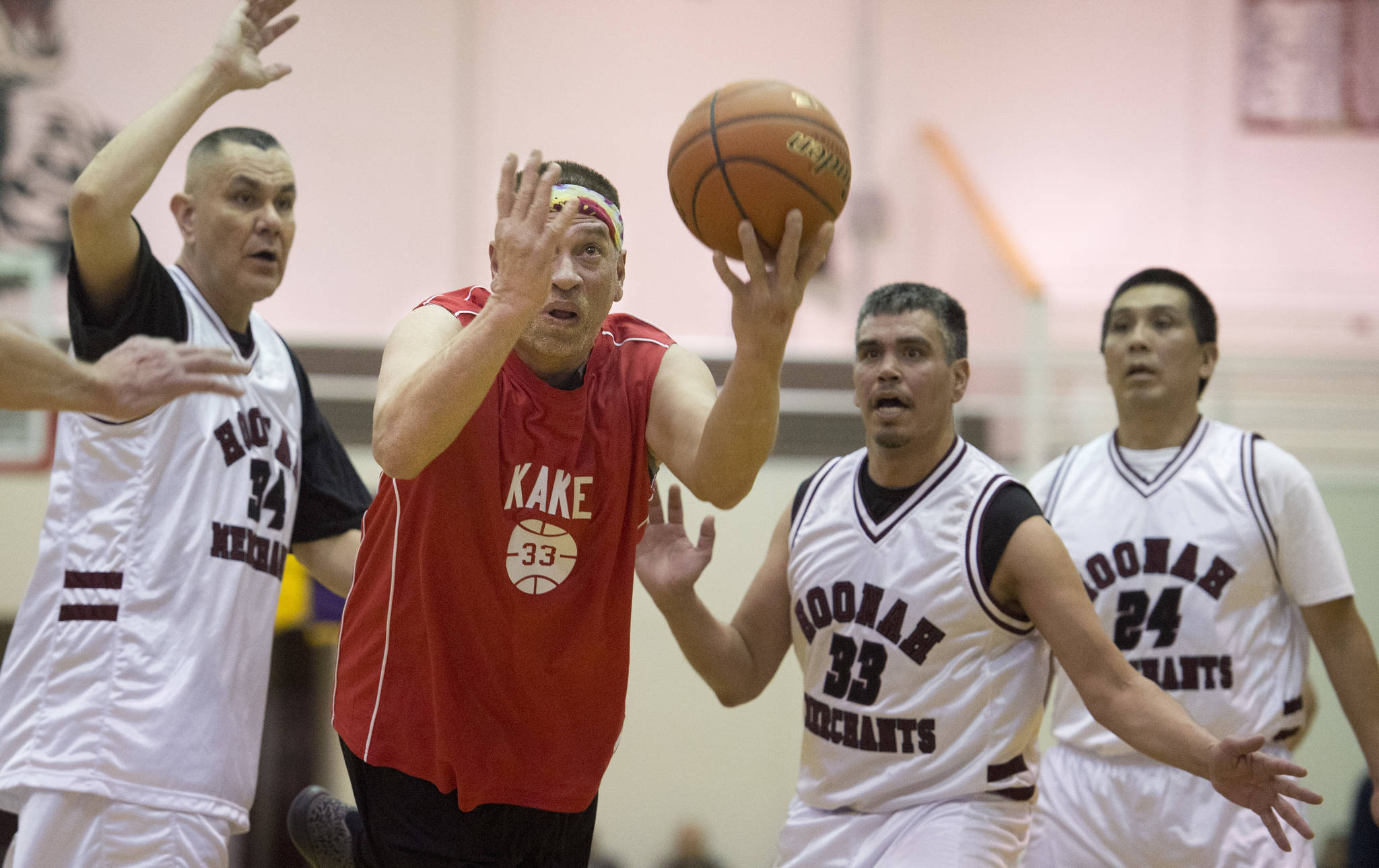 Kake’s Nick Davis, right, puts up a shot against Hoonah’s James Mercer, left, Albert Hinchman, center, and Ken Willard during their Masters Bracket game at the Lions Club’s Gold Medal Basketball Tournament at Juneau-Douglas High School on Monday, March 20, 2017. Hoonah won 80-66. (Michael Penn | Juneau Empire)