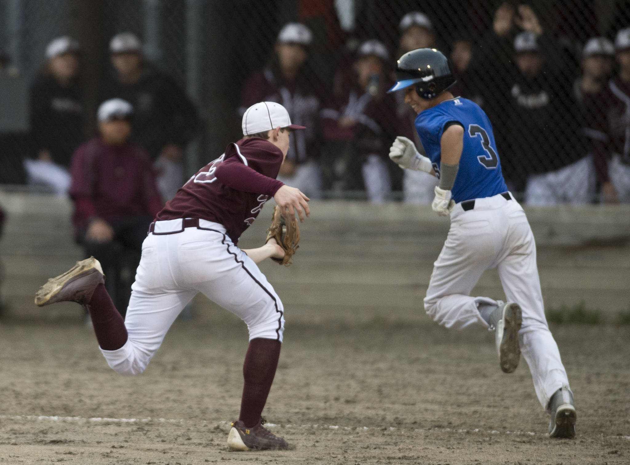 Ketchikan pitcher Jack Carson, left, catches a flyball bunt as Thunder Mountain’ Bryson Echiverri makes a fun for first base in the third inning at Adair-Kennedy Memorial Park on Friday, May 5, 2017. (Michael Penn | Juneau Empire)