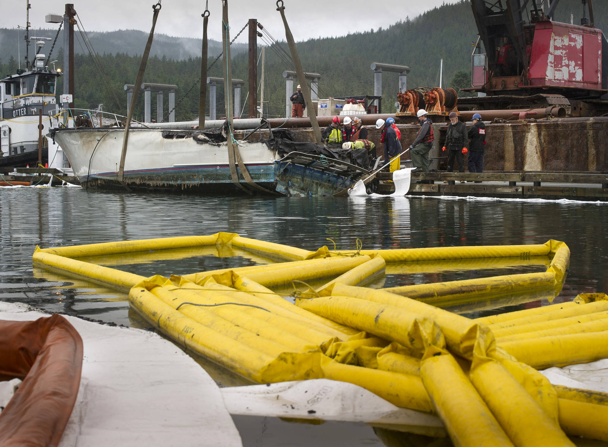 The 42-foot vessel, Whimsea, that sank after a fire early Tuesday morning, is lifted onto a barge by Trucano Construction at the Don D. Statter Memorial Harbor on Friday, June 30, 2017. (Michael Penn | Juneau Empire File)