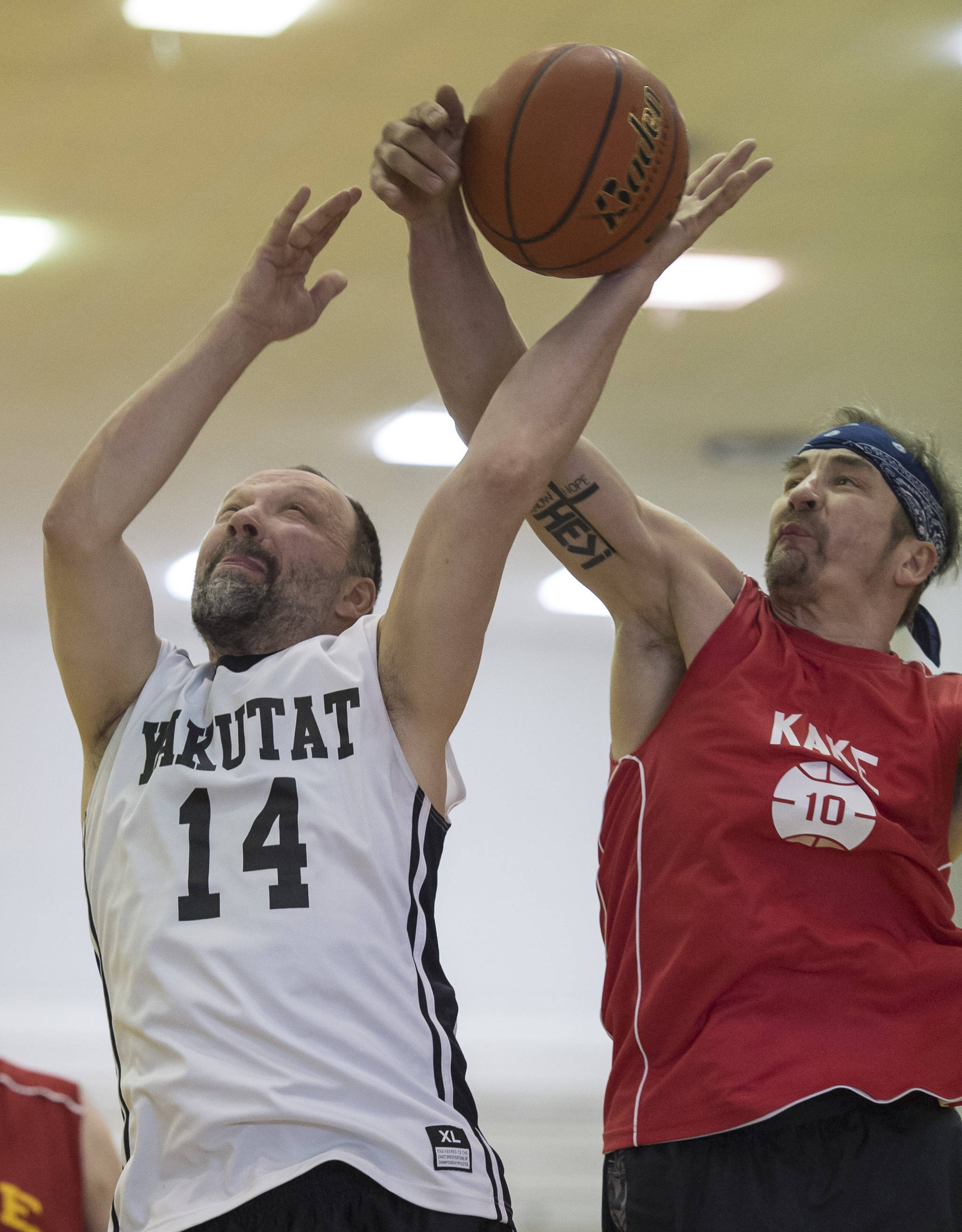 Kake’s Keith Nelson, right, blocks a shot by Yakutat’s Greg Indreland in the Masters bracket in the Juneau Lion’s Gold Medal Basketball Tournament at Juneau-Douglas High School on Wednesday, March 21, 2018. Kake won 60-50. (Michael Penn | Juneau Empire)