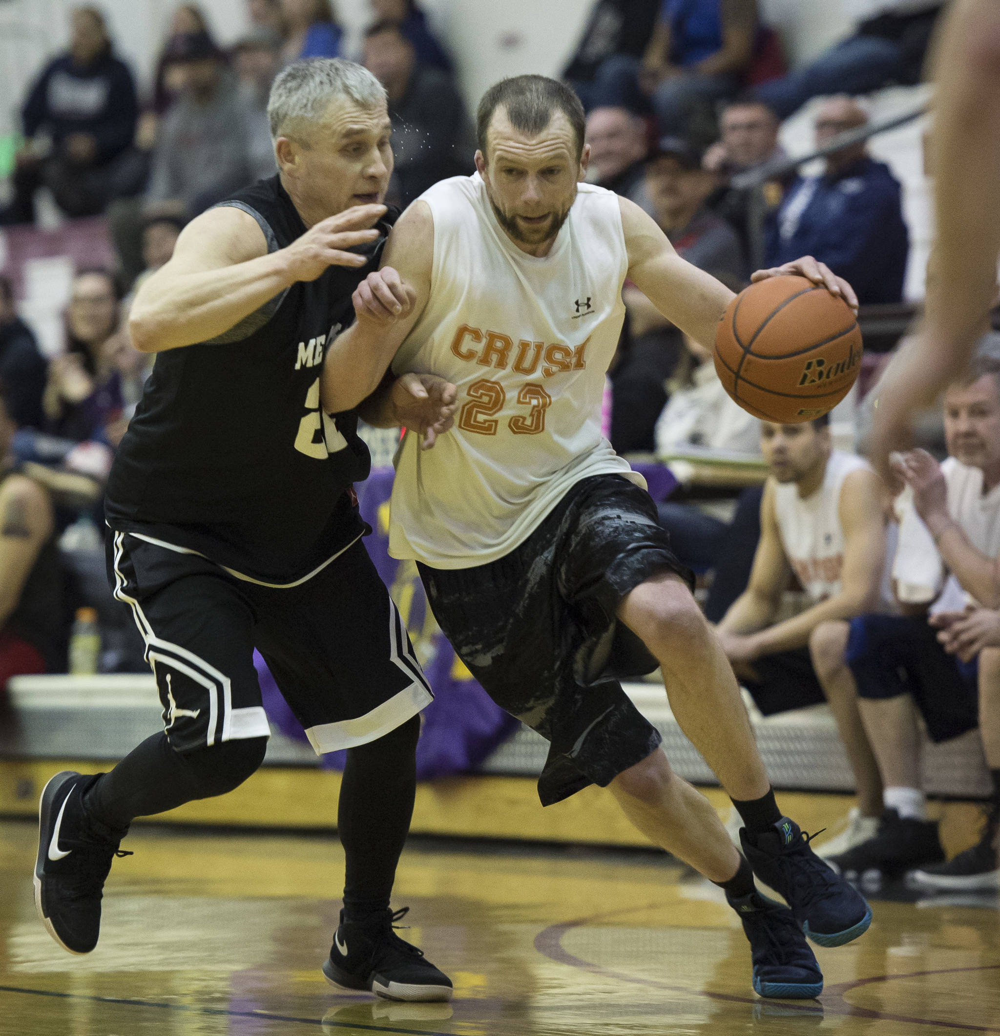 Juneau Crush’s Alex Heumann, right, drives against Metlakatla’s Archie Dundas in a C bracket game in the Juneau’s Lion’s Gold Medal Basketball Tournament at Juneau-Douglas High School on Thursday, March 22, 2018. (Michael Penn | Juneau Empire)