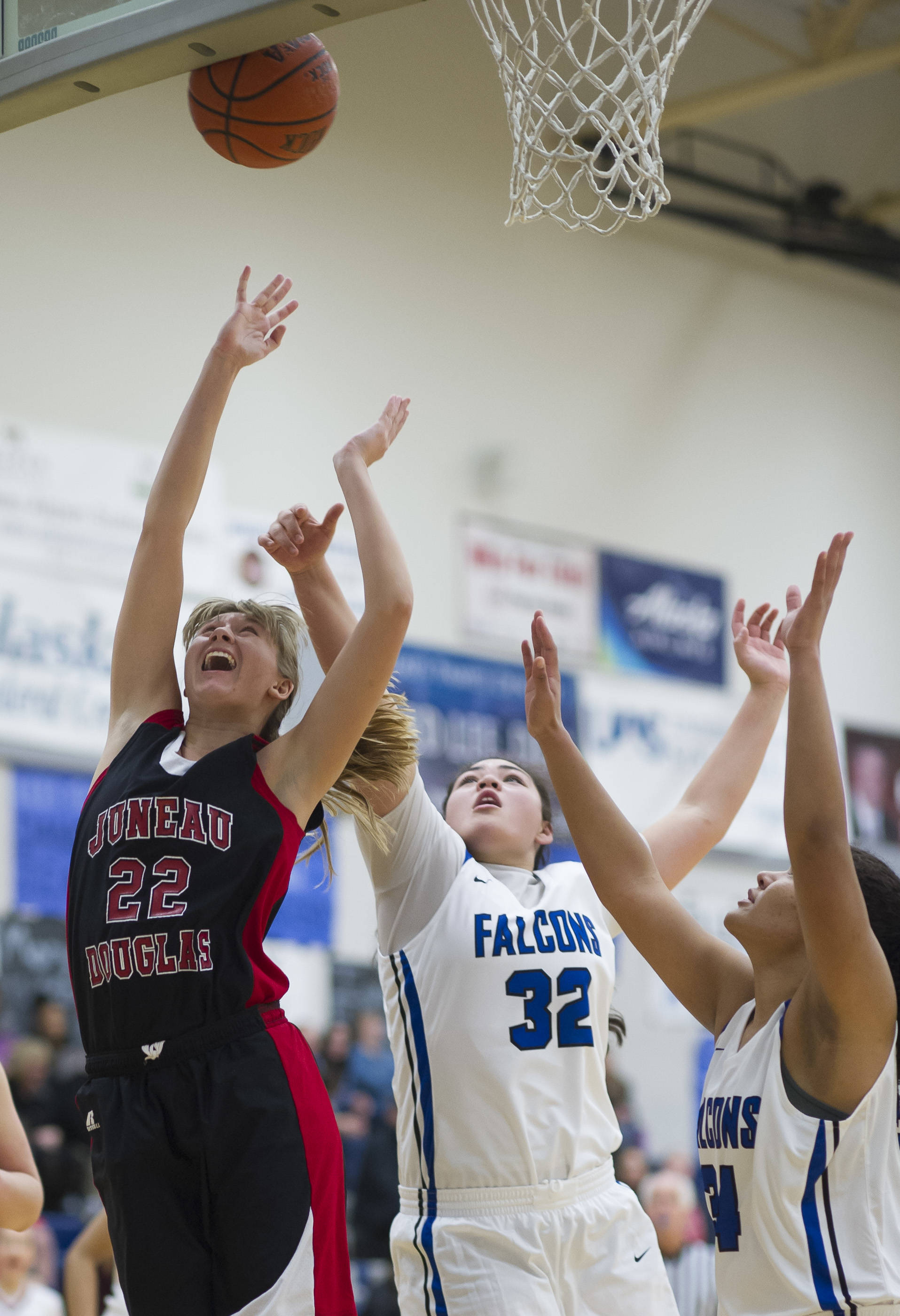 Juneau-Douglas’ Caitlin Pusich, left, shoots under the basket against Thunder Mountain’s Nina Fenumiai, center, and Kyra Jenkins-Hayes during their game at TMHS on Friday, Jan. 5, 2017. JDHS won 53-33. (Michael Penn | Juneau Empire File)