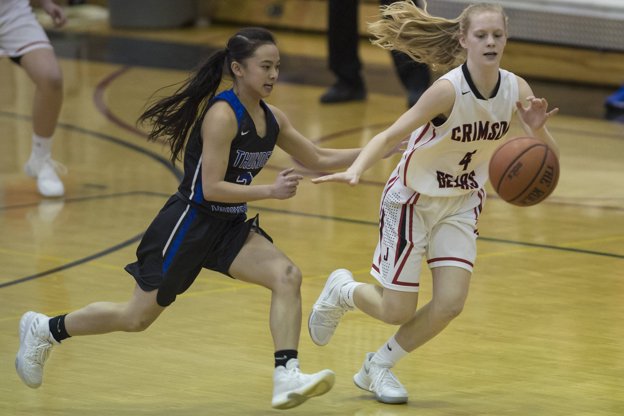 Thunder Mountain’s Khaye Garcia, left, and Juneau-Douglas’ Sadie Tuckwood chase down a loose ball at JDHS on Friday, March 3, 2018. JDHS won 53-33. (Michael Penn | Juneau Empire File)