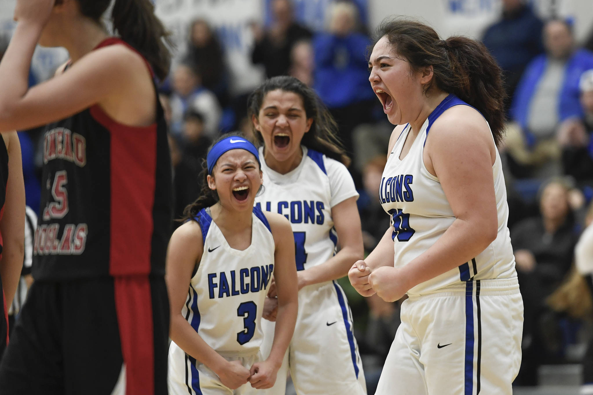 Thunder Mountain’s Tasi Fenumiai, right, celebrates a point with teammates Mary Neal Garcia, left, and Charlee Lewis against Juneau-Douglas’ Sadie Tuckwood and Skylar Hickok at TMHS on Friday, Feb. 1, 2019. (Michael Penn | Juneau Empire)