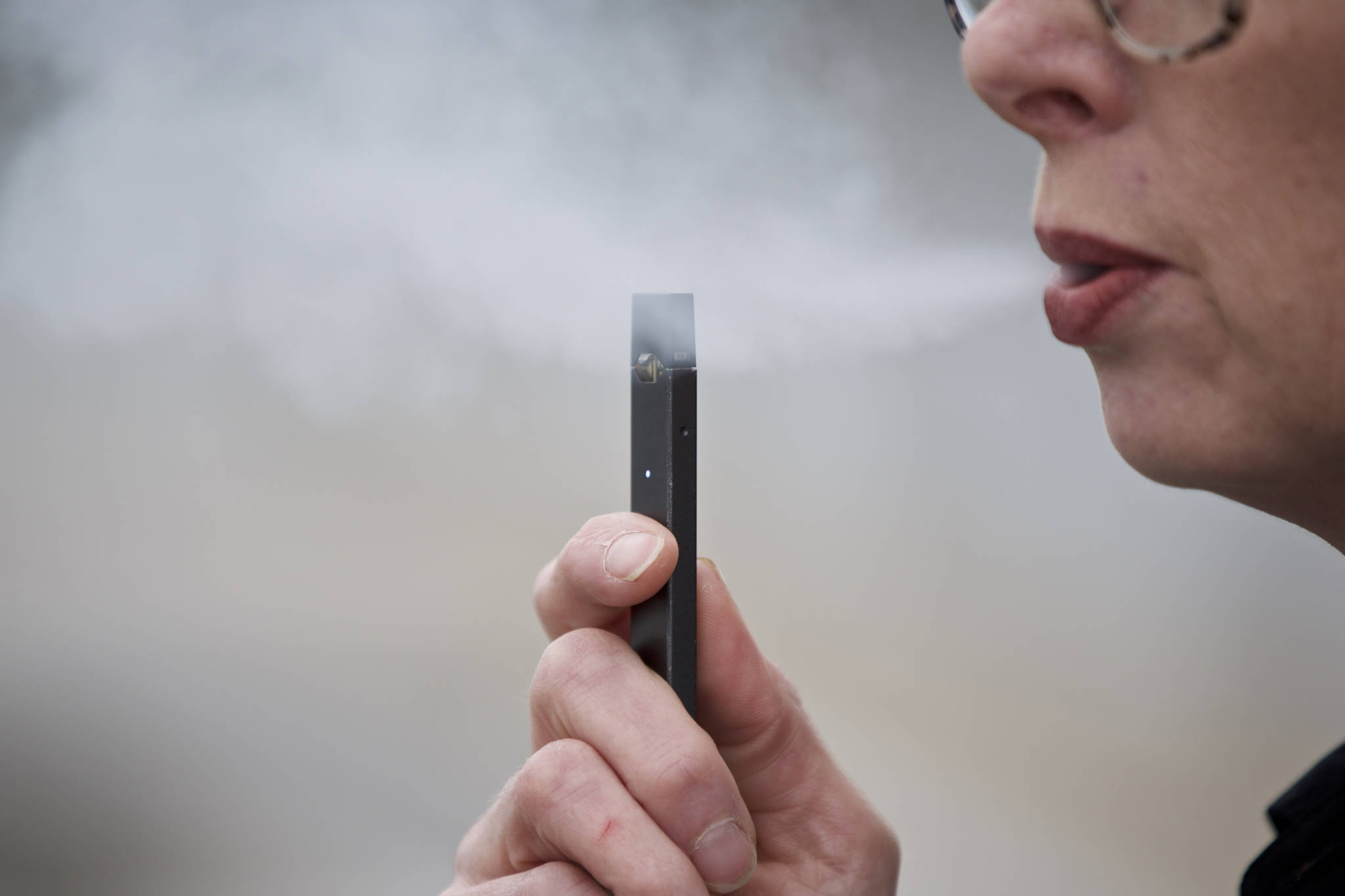 Chantel Williams exhales a puff of vapor from a Juul pen in Vancouver, Washington on April 16, 2019. (Craig Mitchelldyer | Associated Press)