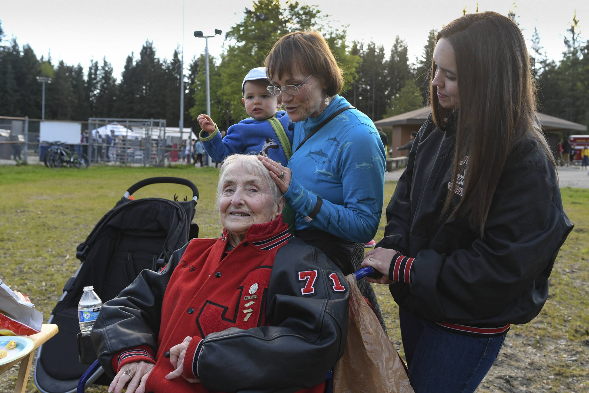 Charlotte Bain, 94, attends a tailgate party with her daughter, Claudia Bain, her granddaughter, Megan White, and her great-granddaughter, Louisa White, 21 months, before the Juneau Alumni Football Game with football players, dance team members and cheerleaders from Juneau-Douglas and Thunder Mountain High Schools at Adair-Kennedy Memorial Field on Friday, May 24, 2019. They were there to support Bain’s grandson, James, who was playing for the Juneau Legends. White graduated in 2000. (Michael Penn | Juneau Empire)