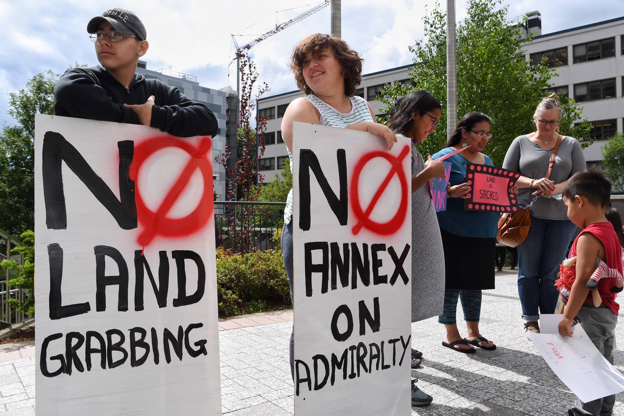 Cousins Michael Fred, 14, Christine Coulson, 13, hold signs during a protest against the City and Borough of Juneau’s annexation of parts of Admiralty Island in front of the Capitol on Friday, June 14, 2019. (Michael Penn | Juneau Empire)