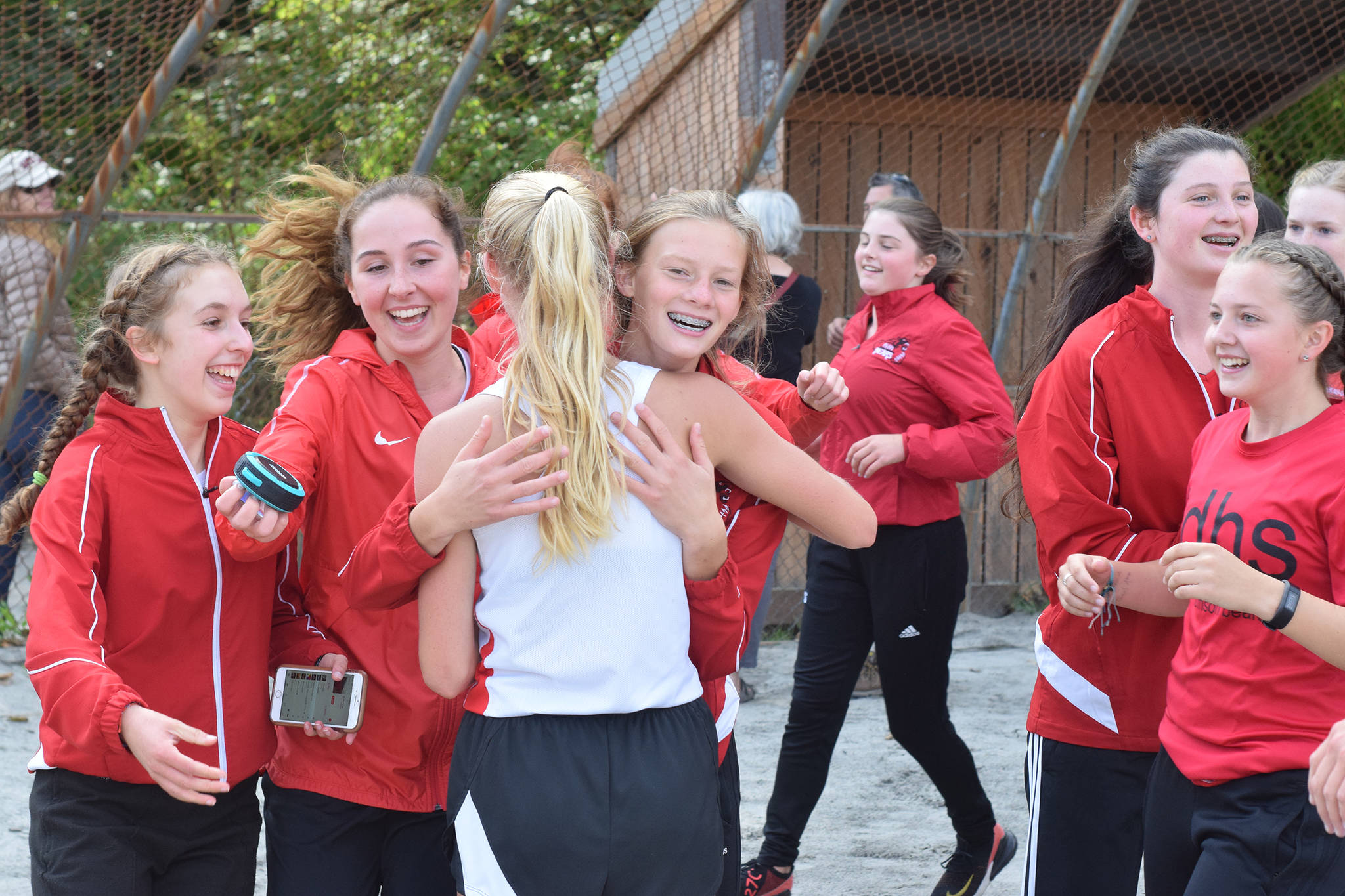 Juneau-Douglas High School: Yadaat.at Kale’s Sadie Tuckwood is congratulated on her teammates after finishing in 11th place in the boys race of the Capital City Invitational at Sandy Beach on Saturday, Aug. 31, 2019. (Nolin Ainsworth | Juneau Empire)