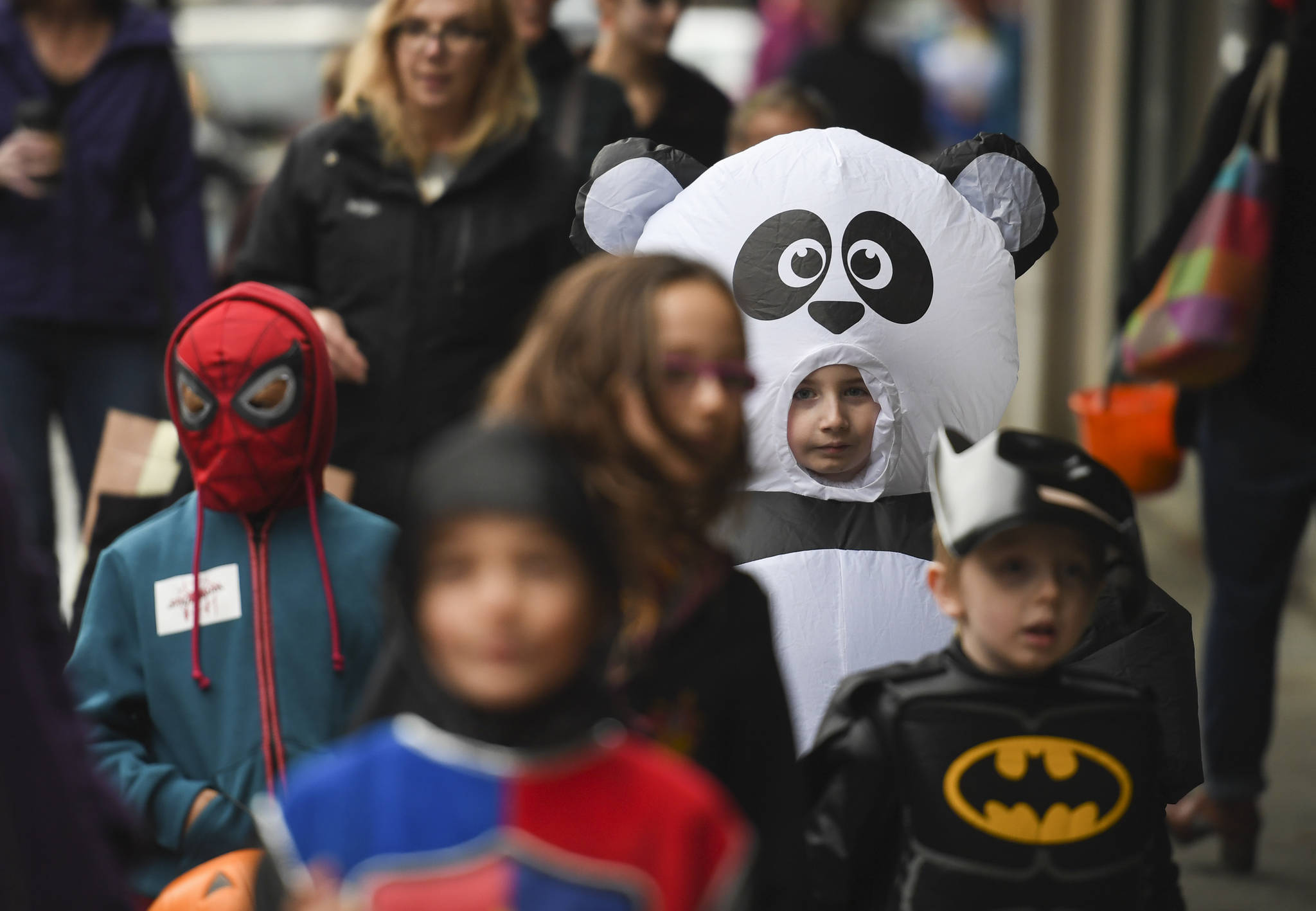 JJ bontadelli, 8, dressed in a blowup panda suit, makes his way along Front Street with his friends during the Trick or Treat Downtown event on Thursday, Oct. 31, 2019. More than 70 business put out orange balloons to participate in the event aimed at young children. (Michael Penn | Juneau Empire)