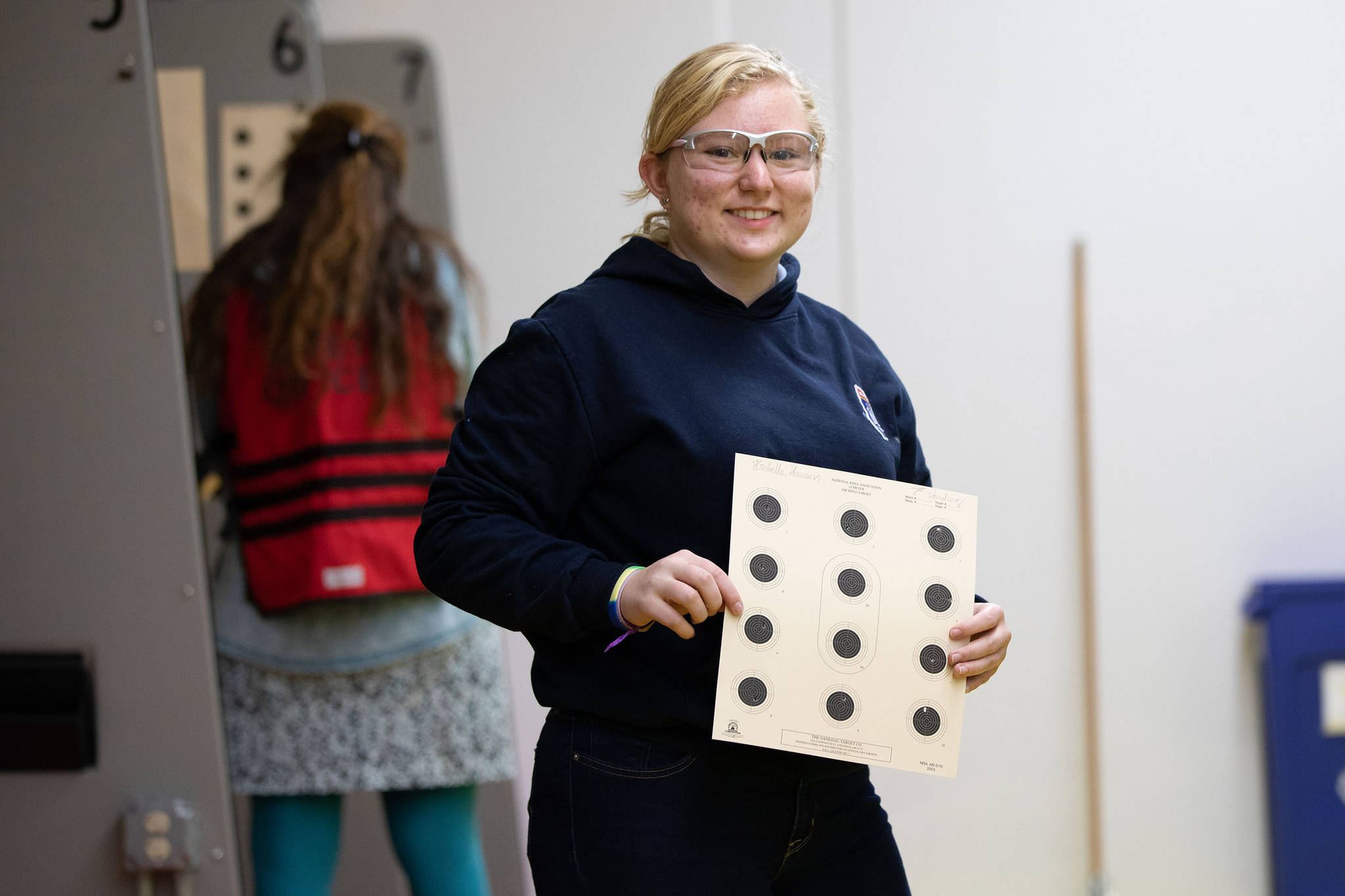 Juneau School District Rifle Team’s Isabelle Hansen holds up her paper target during a match at the ADFG Hunter Education Shooting Complex. (Courtesy Photo | Carol Lahnum/Crow Fox Photography)