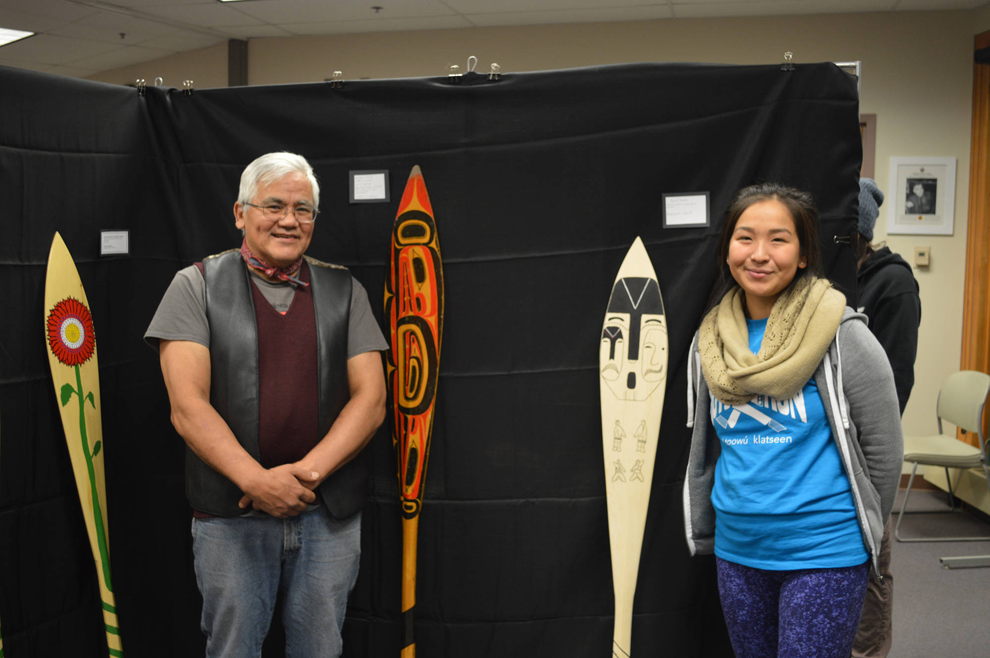 Wayne Price, associate professor of Northwest Coast art and Tlingit artist, and student Kaytlynne Lewis pose with their paddles at a recent Northwest Coast arts showcase. (Courtesy Photo | Davina Cole)