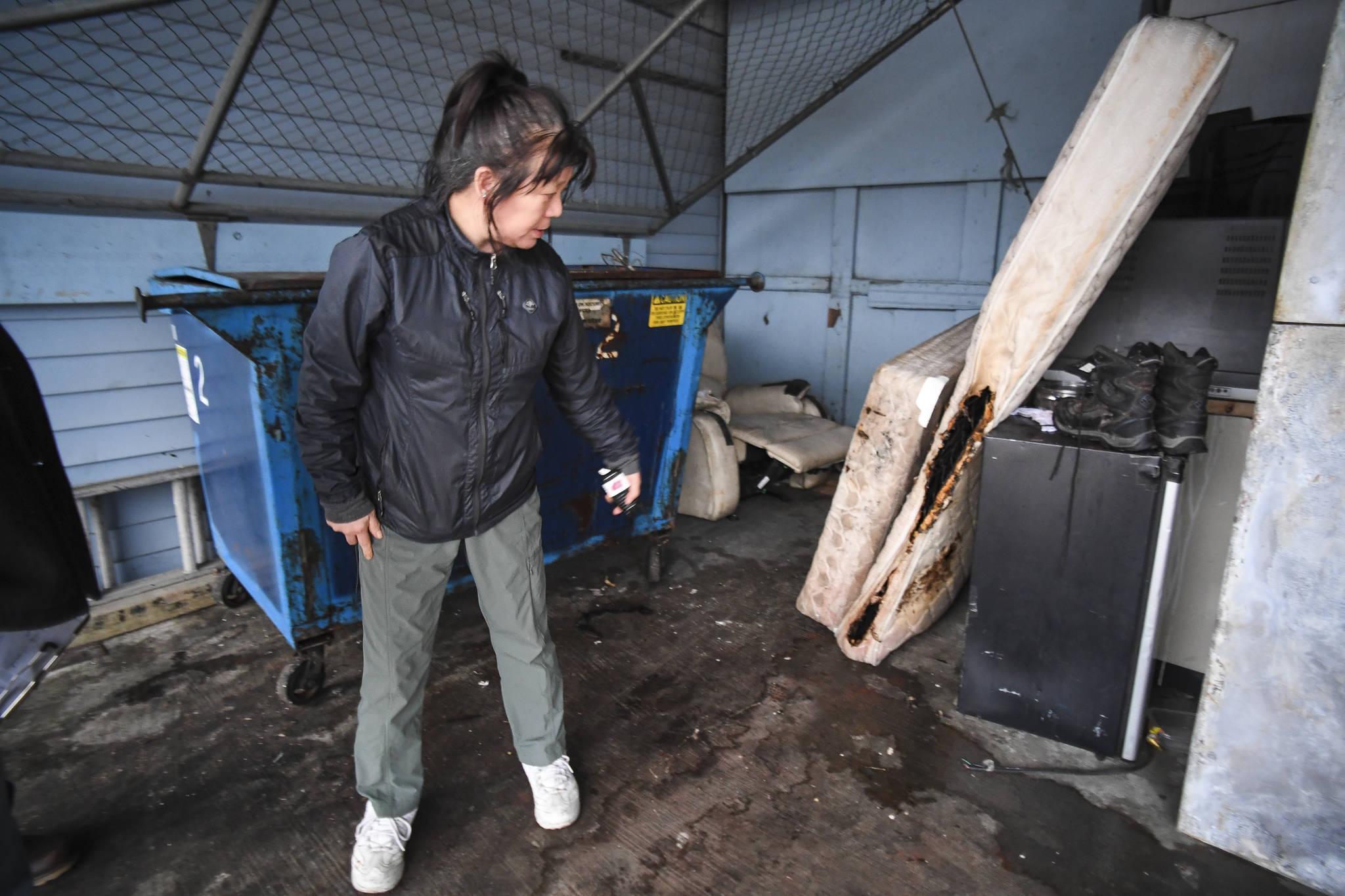 Gina Chi-Mott, general manager of the Breakwater Inn, shows a burned mattress on Monday, Dec. 16, 2019, from a room fire on Sunday. (Michael Penn | Juneau Empire)