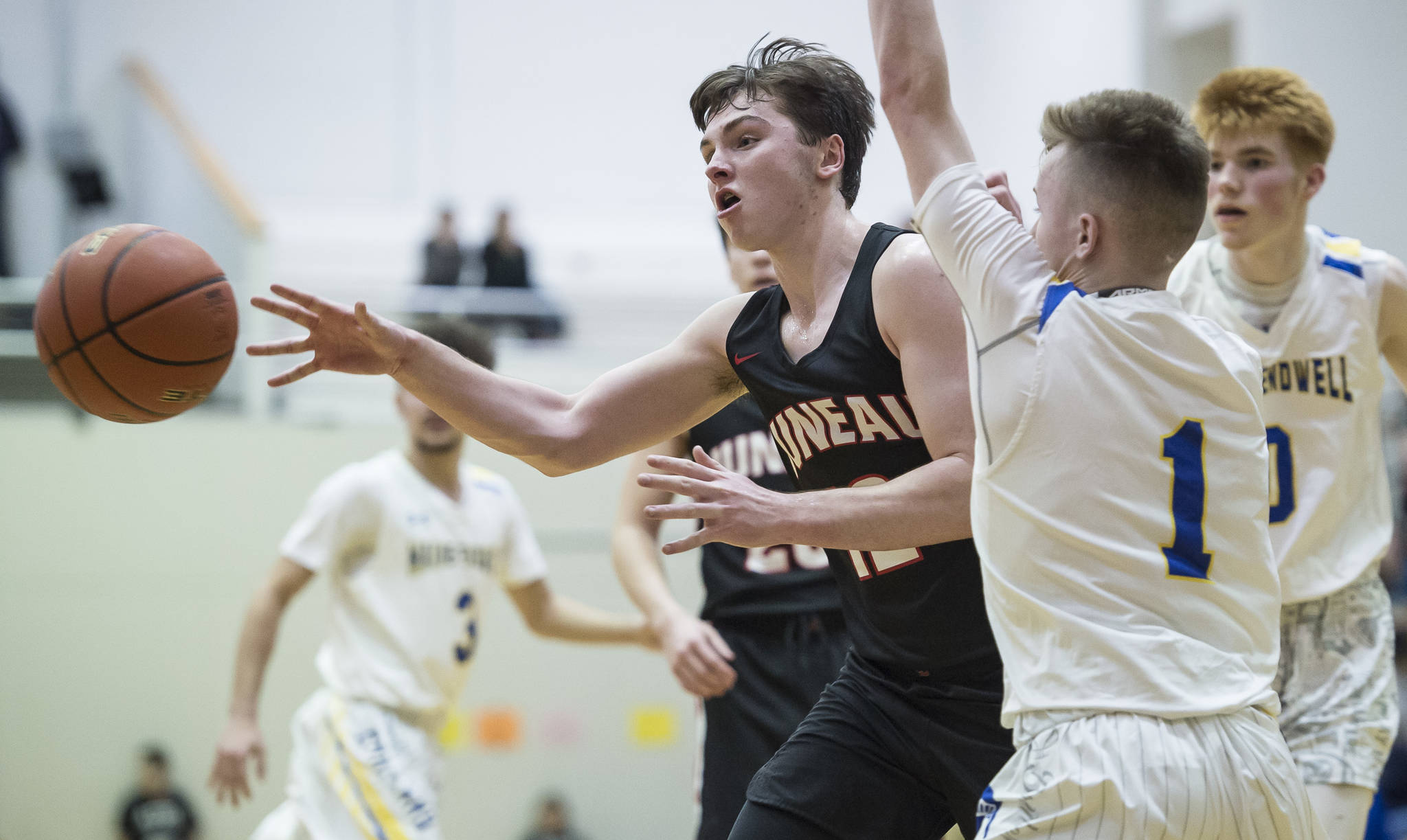 Juneau-Douglas’ Brock McCormick, left, passes away from Maine-Endwell’s Jack Coleman and Gannon Russell, right, at the Princess Cruises Capital City Classic at Juneau-Douglas High School on Saturday, Dec. 29, 2018. Juneau-Douglas won 66-61. (Michael Penn | Juneau Empire File)