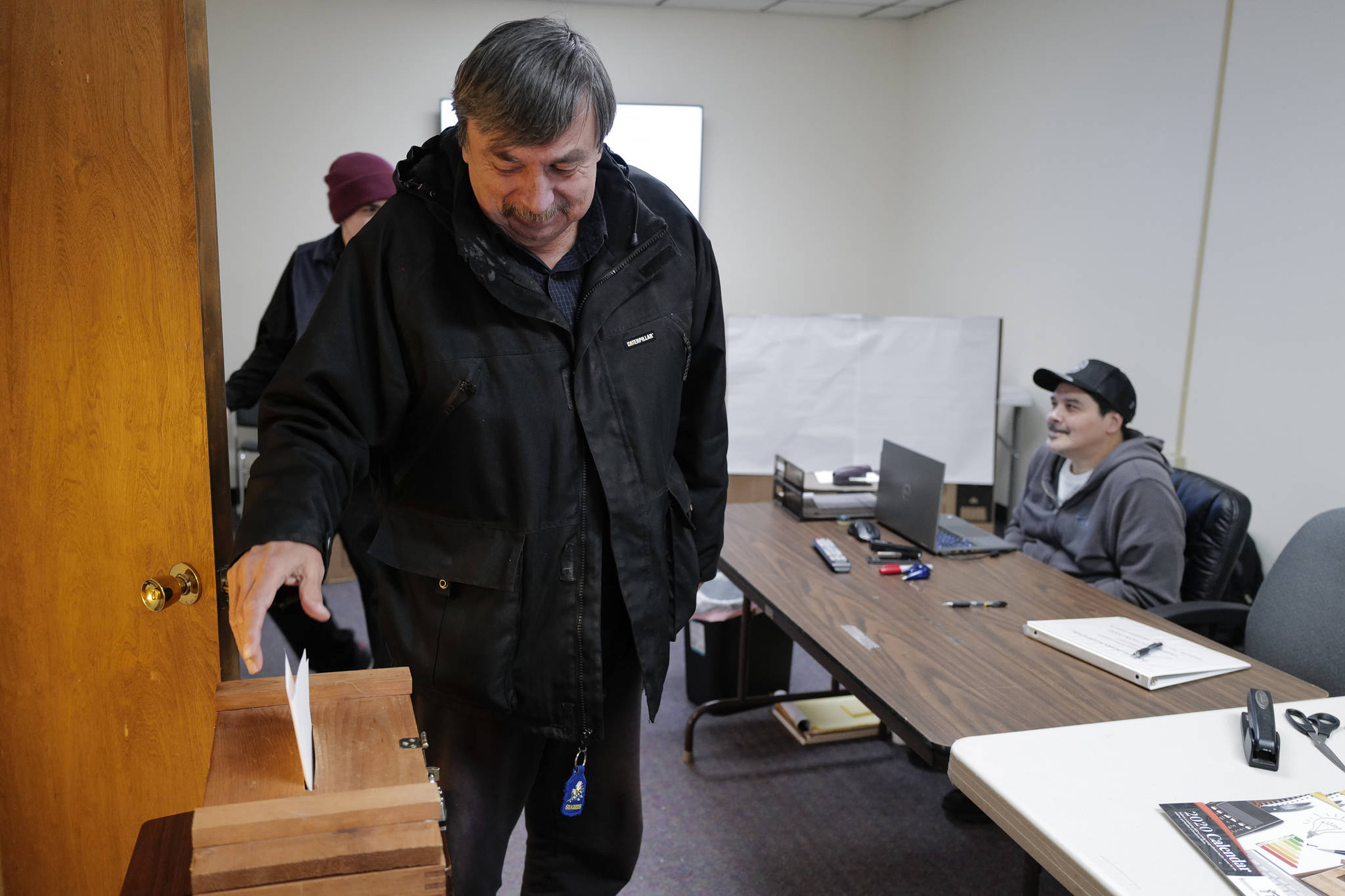 Ron Laiti drops his ballot into a ballot box after voting in the Douglas Indian Association’s election on Wednesday. (Michael Penn | Juneau Empire)