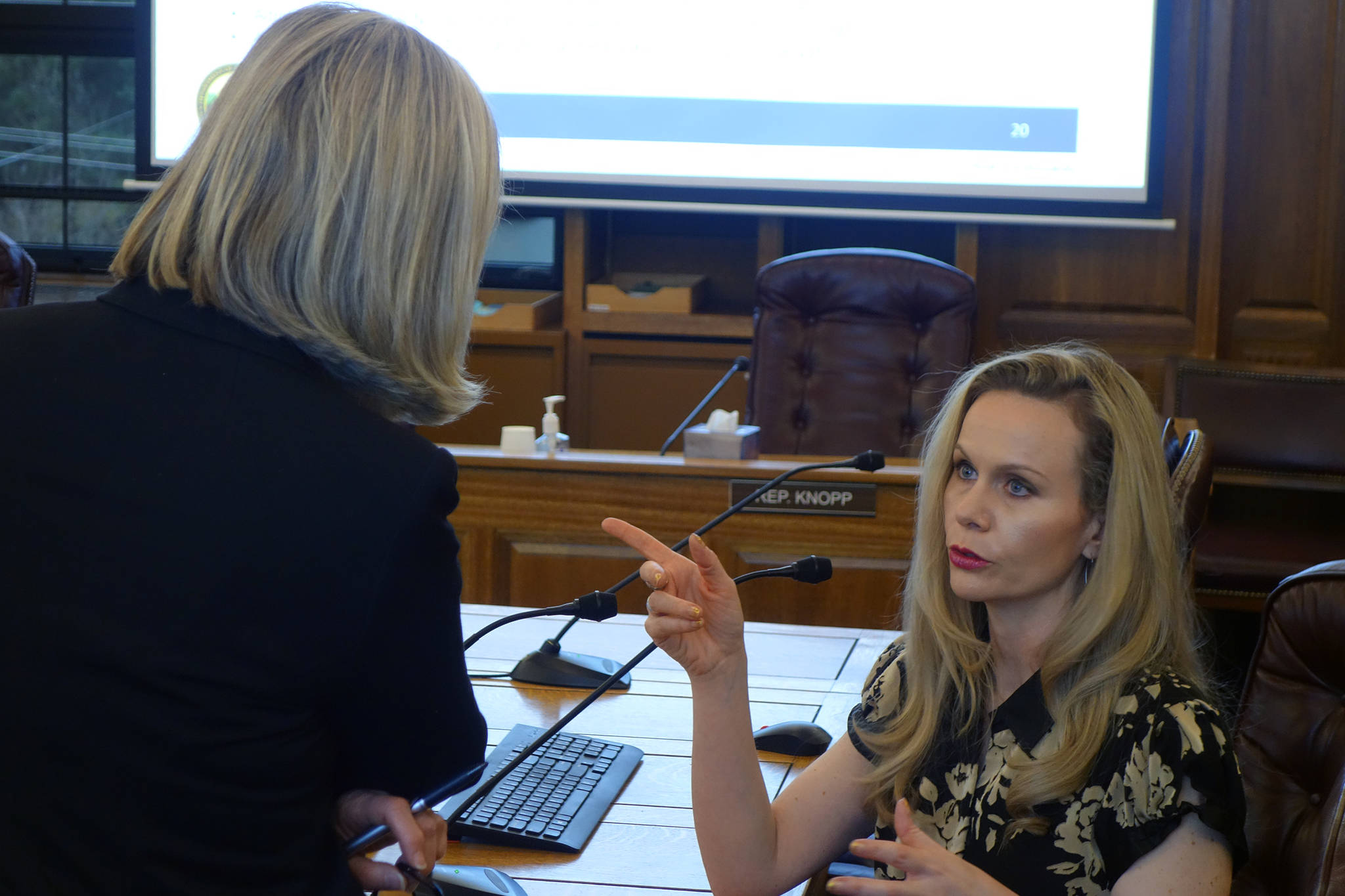 Rep. Andi Story, D-Juneau, talks with Department of Administration Commissioner Kelly Tshibaka Tuesday morning following a House Administration Committee Finance Subcommittee meeting. (Ben Hohenstatt | Juneau Empire)