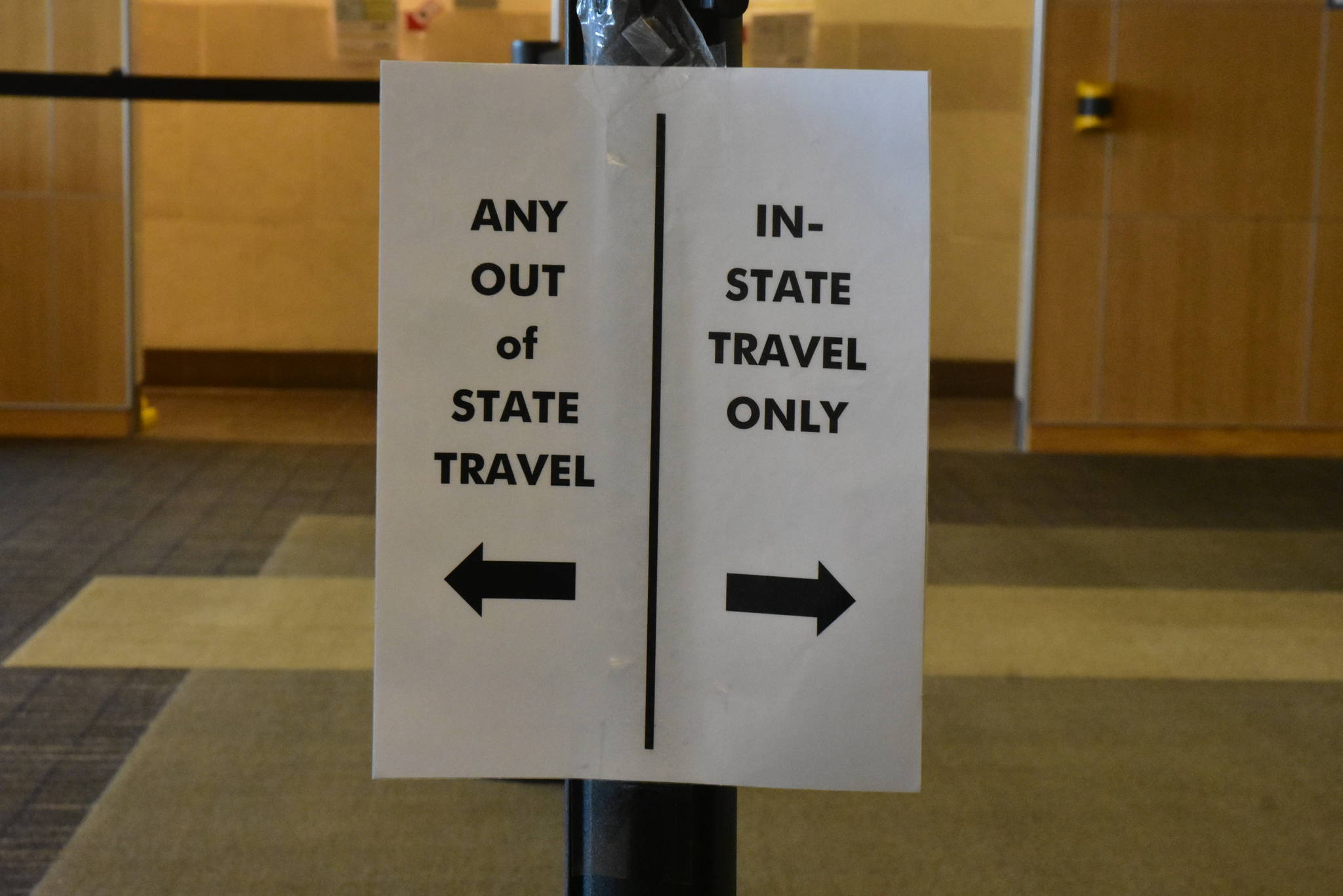 A sign at Juneau International Airport directing arriving travelers on July 28, 2020. Under updated travel restrictions, non-resident travelers will now have to produce negative COVID-19-test results before entering the state. (Peter Segall / Juneau Empire)