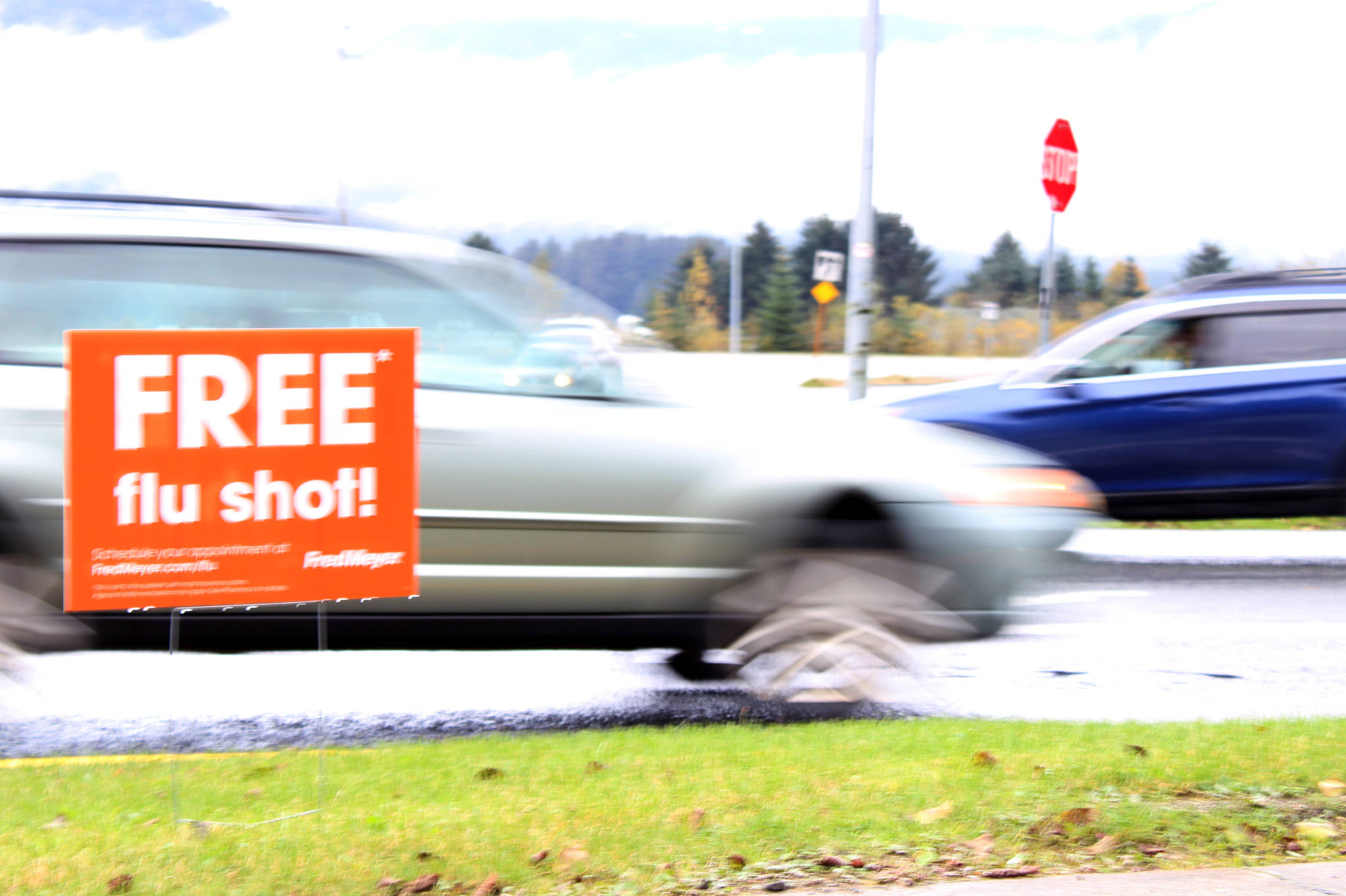 Vehicles drive past a sign advertising free flu shots near Fred Meyer on Thursday, Sept. 24, 2020. Health officials advise that Alaskans should get the widely available vaccinations to prevent over-burdening hospitals as the COVID-19 pandemic and annual flu epidemic are poised to collide. (Ben Hohenstatt / Juneau Empire)