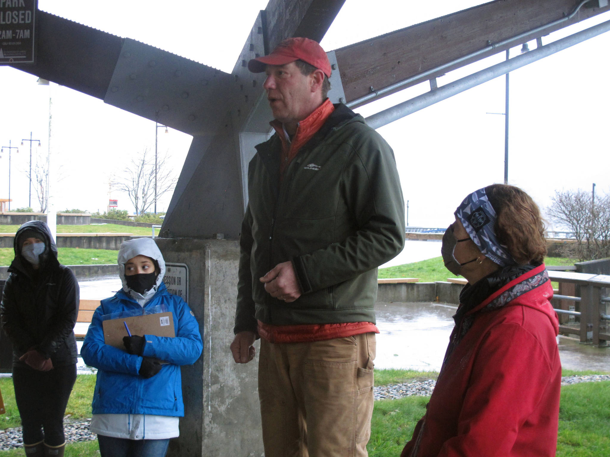 Alaska U.S. Senate candidate Al Gross speaks to supporters at an event at a downtown park in Juneau, Alaska, on Saturday, Oct. 31, 2020, as his wife, Monica Gross, at right, looks on. The event, held on a rainy, windy morning, is among those Gross is holding in the lead-up to the Nov. 3, 2020, general election, in which Gross, an independent running with Democratic backing, is facing Republican U.S. Sen. Dan Sullivan. (AP Photo / Becky Bohrer)