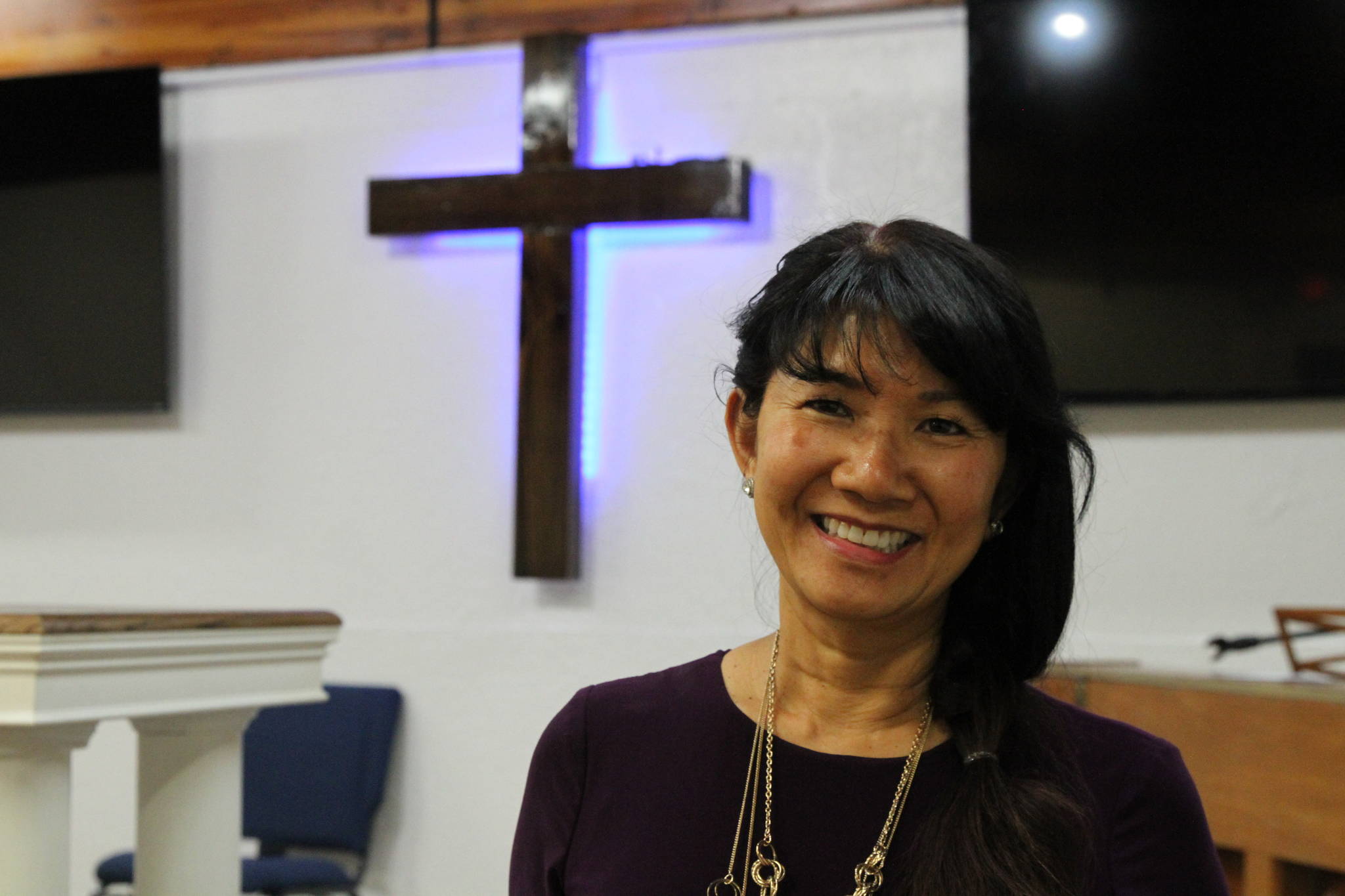 In this May 24, 2021, photo, Linda Dunegan poses for a photo in the sanctuary of the Open Door Baptist Church in Anchorage, Alaska. Dunegan purchased a former strip club and leased the main floor to the church. (AP Photo/ Mark Thiessen)