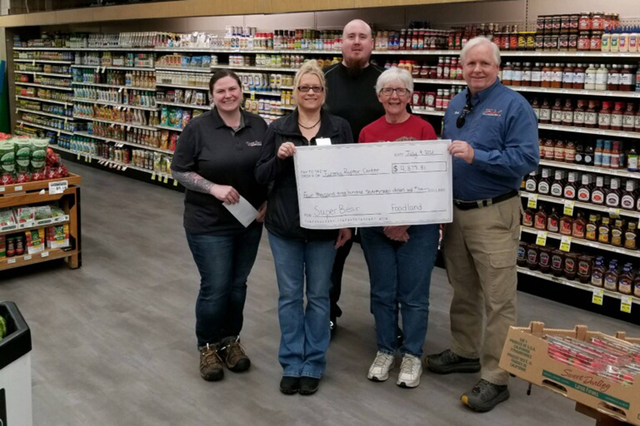 This photo shows Kelly Crow,  Super Bear IGA  store director; Kathy Benner,  Juneau Raptor Center manager; JP Oudekerk, Super Bear IGA assistant manager; Pat Bock with Juneau Raptor Center; and Rick Wilson, Foodland IGA/Ace Hardware store director. (Courtesy Photo)