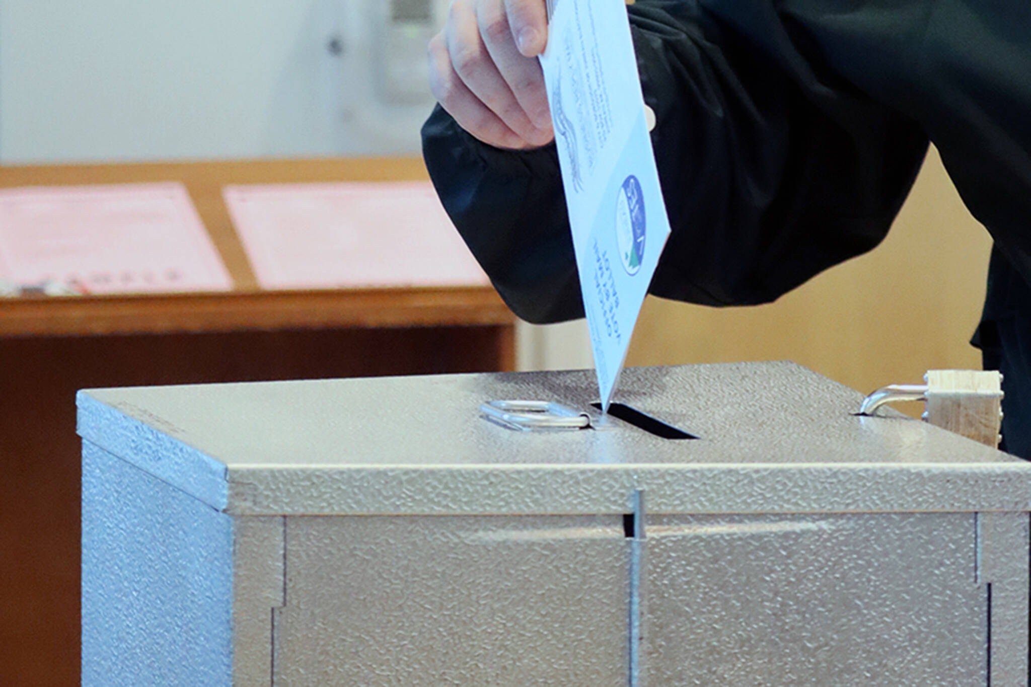 A voter places a ballot in the drop box at the Mendenhall Public Library vote center on Tuesday, Oct. 5. Ben Hohenstatt / Juneau Empire)