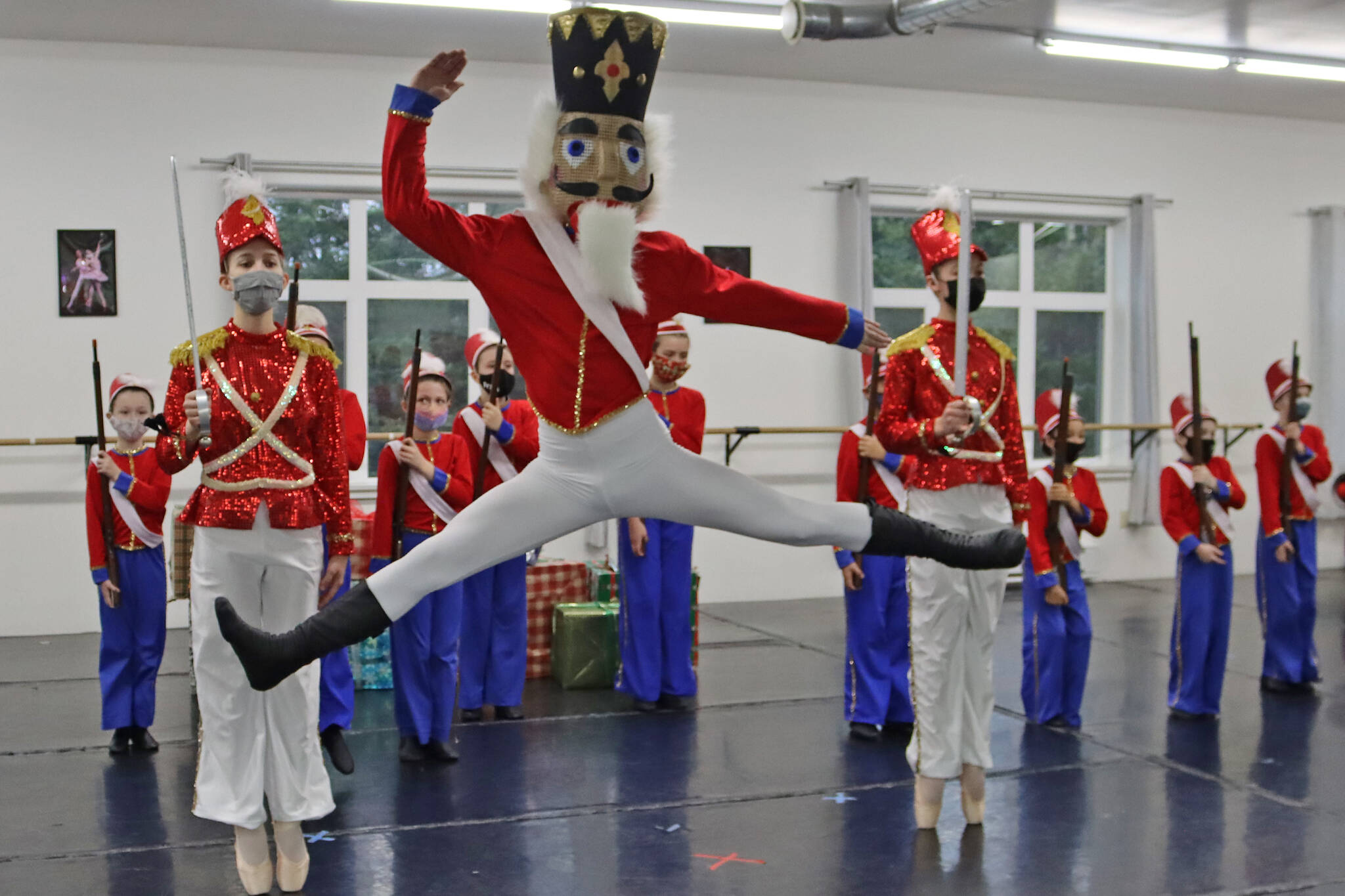 Viktor Bell rehearses his role in "The Nutcracker" on Saturday, Nov. 27. Lead soldiers Grace Bultez and Ainsley Mallott stand guard. (Ben Hohenstatt/Juneau Empire)