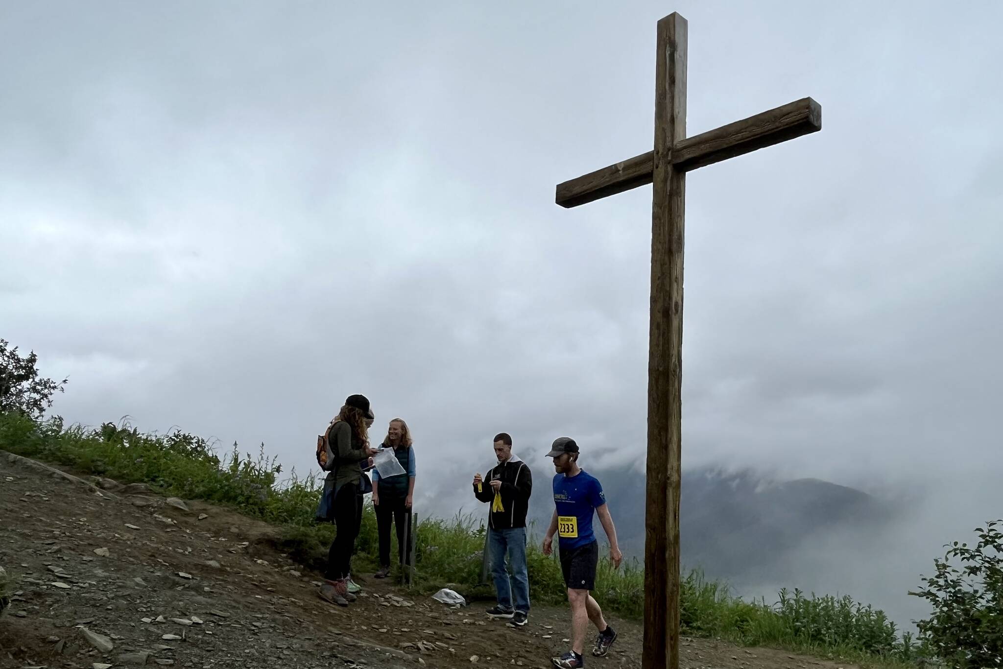 Juneau resident Quinn Tracy tags Father Brown’s Cross to receive his time from Juneau Trail and Road Runners volunteers. Tracy won the virtual race in 2021. (Jonson Kuhn / Juneau Empire)