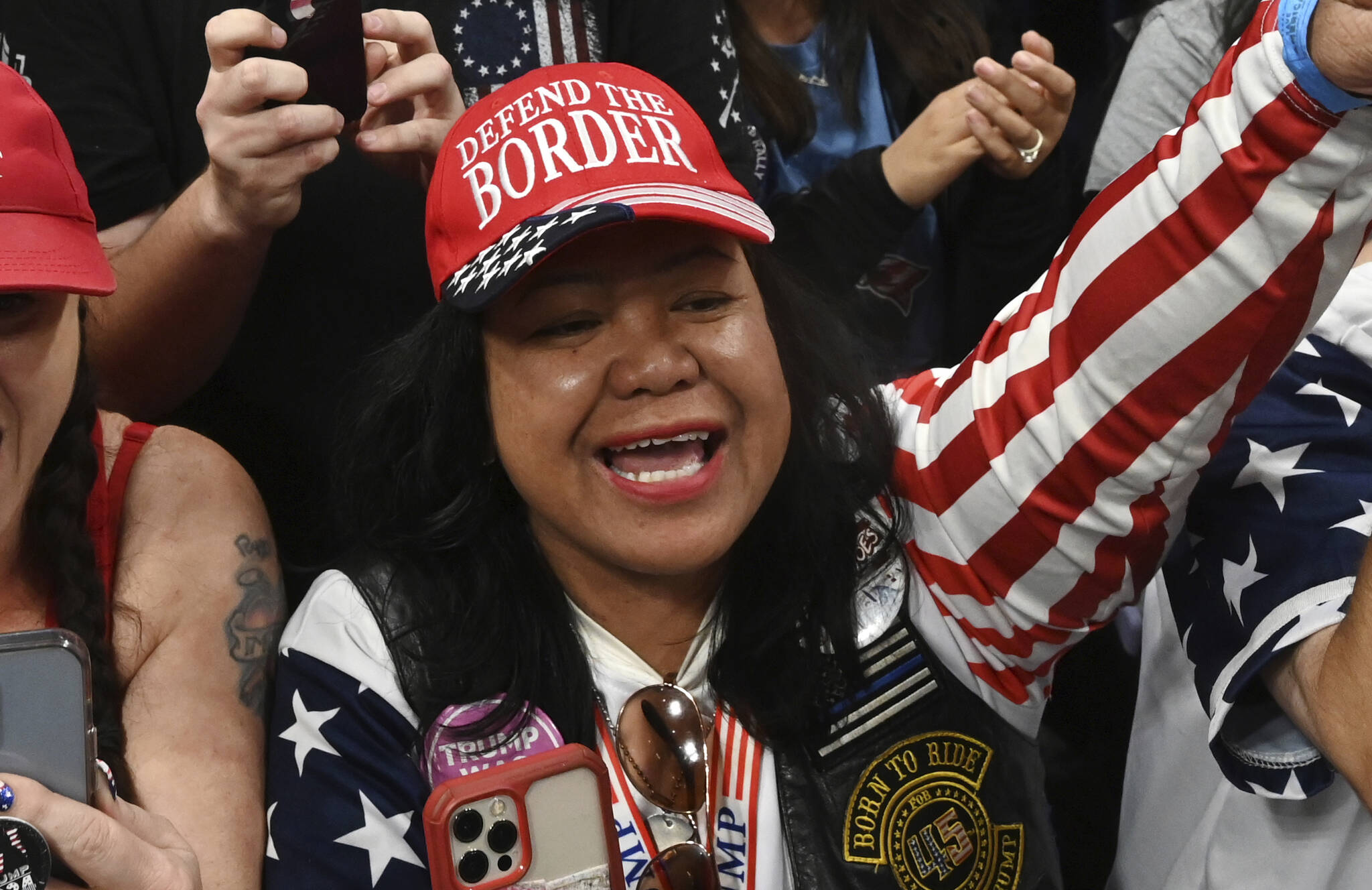 Mimi Israelah, center, cheers for Donald Trump inside the Alaska Airlines Center in Anchorage, Alaska, during a rally Saturday July 9, 2022. An investigation has been launched after a person believed to be an Anchorage, Alaska, police officer was shown in a photo with Israelah flashing a novelty “White Privilege card.” The social media post caused concerns about racial equality in Alaska’s largest city. (Bill Roth / Anchorage Daily News)