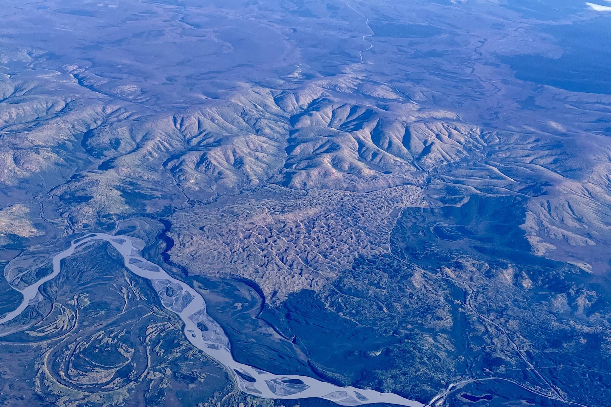 A vegetated sand dune that formed between the Tanana River, Interior Alaska hills and the Taylor Highway, as seen from a flight from Seattle to Fairbanks. The Alaska Highway Bridge over the Tanana River is visible at bottom. (Courtesy Photo / Ned Rozell)