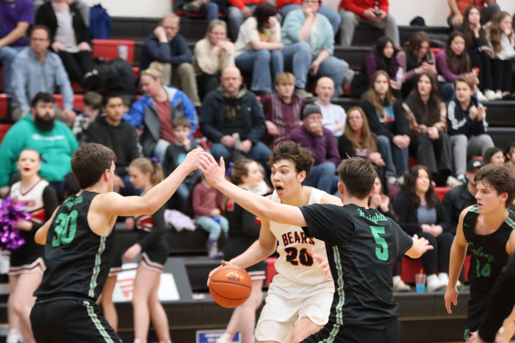 JDHS senior Orion Dybdahl takes the ball down court while being closely guarded by two defenders on Wednesday night’s game. Dybdahl led the Crimson Bears in scoring with 19 points. (Jonson Kuhn / Juneau Empire)