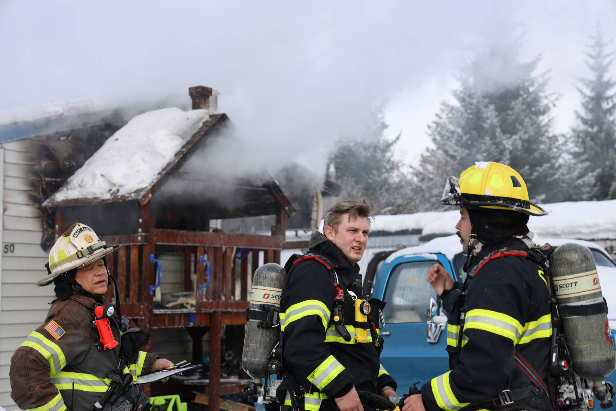 Capital City Fire/Rescue firefighters move to extinguish a trailer fire Friday morning. The cause of the fire is believed to be caused by an electric toaster, officials say.(Clarise Larson / Juneau Empire)
